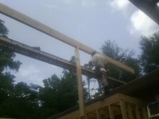 Carpenter setting a ridge beam over a new addition frame — Ice Dam Removal by Roofing Brothers in Windsor